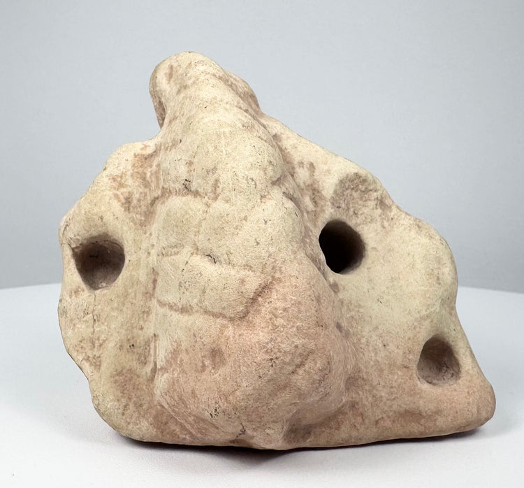 Taíno three-pointed stone ritual object with rounded projections and deliberately carved apertures.