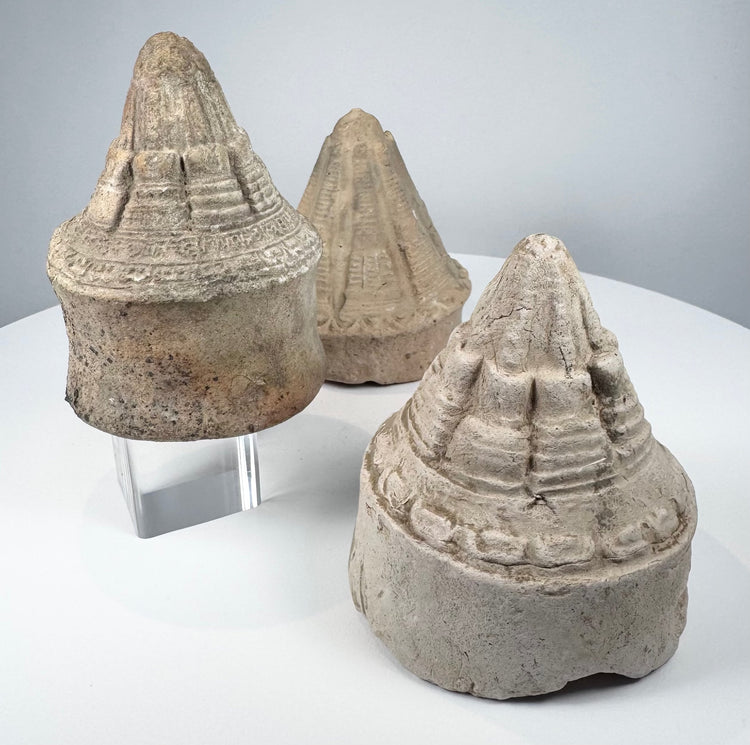 Ancient terracotta Buddhist stupas displaying varied conical forms and intricate architectural detailing