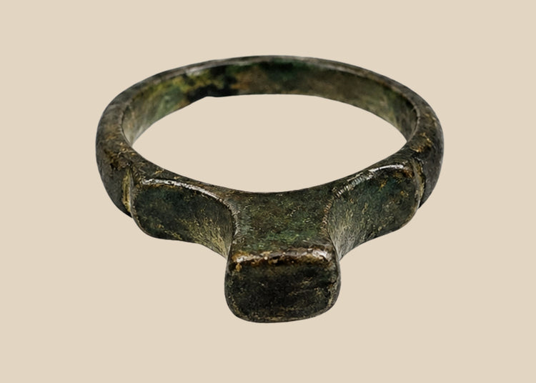 Authentic Roman bronze signet ring, circa 100–300 CE, with rounded band and flat bezel once engraved for sealing documents. Worn smooth from centuries of use, with deep green-black patina and earthen encrustations, a tangible relic of Roman identity.