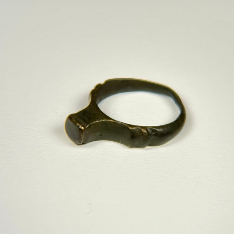 Roman bronze ring with minimalist signet form and naturally weathered green-black surface
