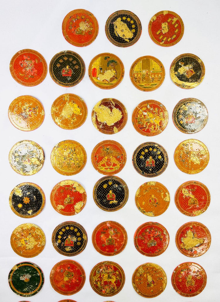 Close-up of hand-painted circular Ganjifa cards with gold leaf and vibrant colors