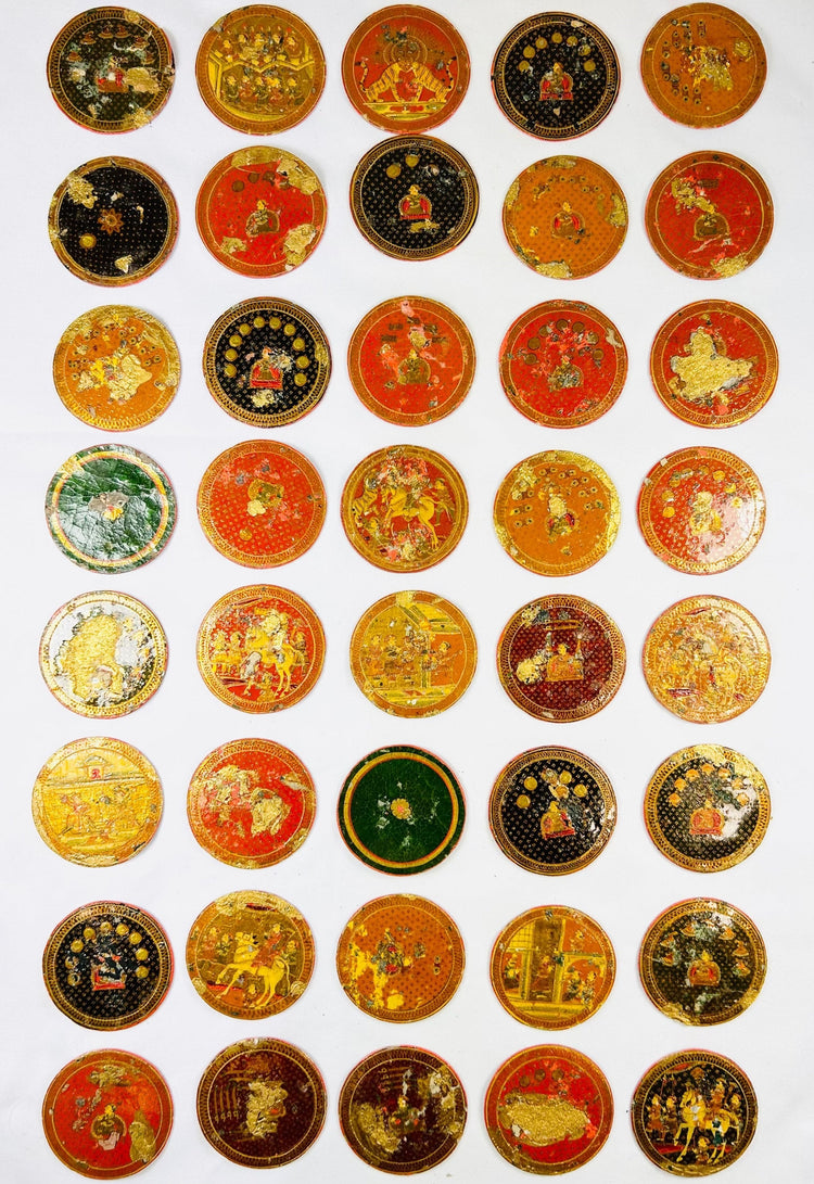 Large grouping of 19th-century Indian Ganjifa round cards arranged in rows, showcasing vibrant hand-painted motifs on a white backdrop.