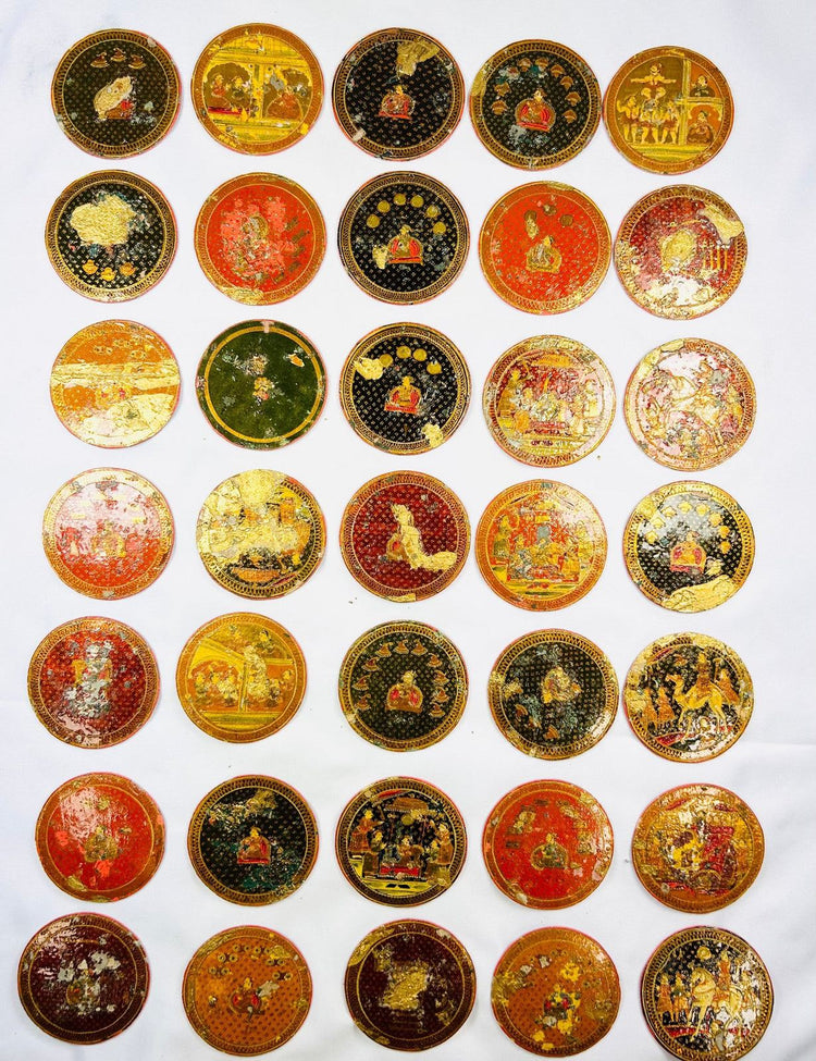 Arrangement of vintage Indian Ganjifa playing cards with intricate gold illustrations