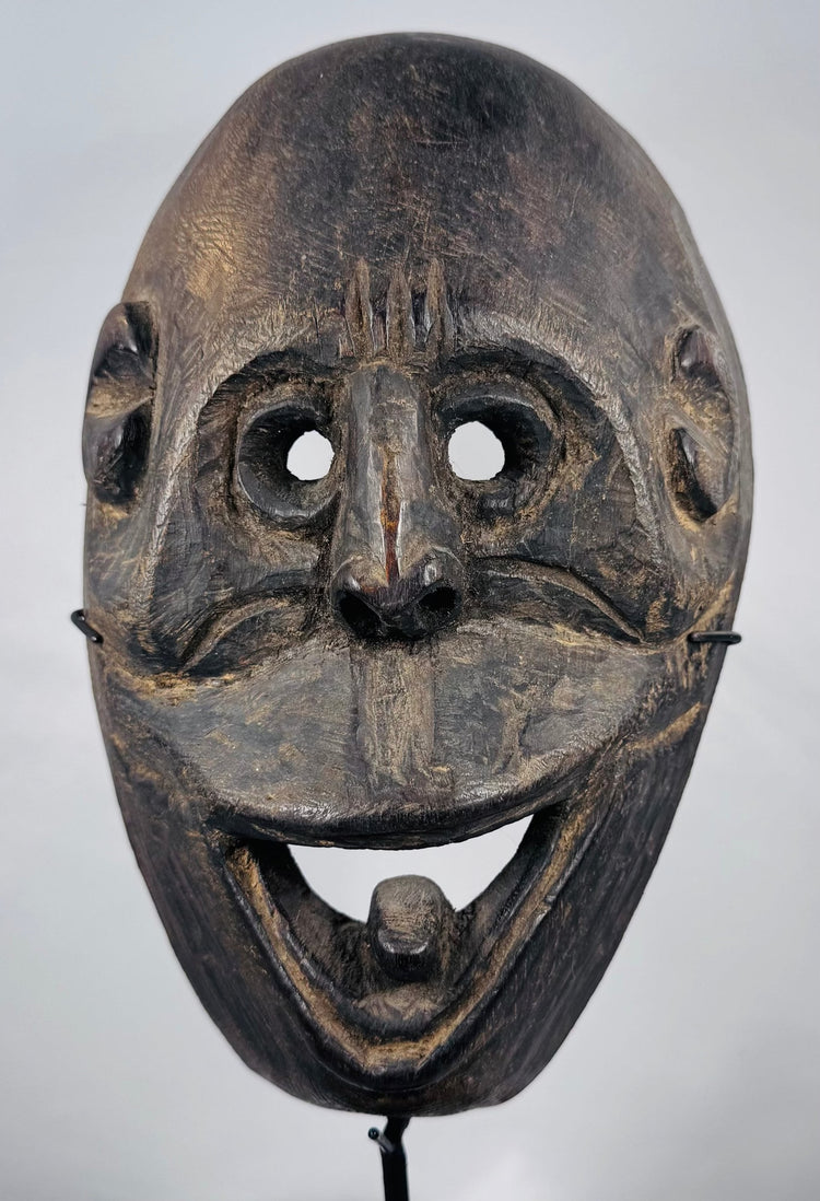 West Timor ceremonial mask hand-carved from hardwood with expressive simian features and aged patina.