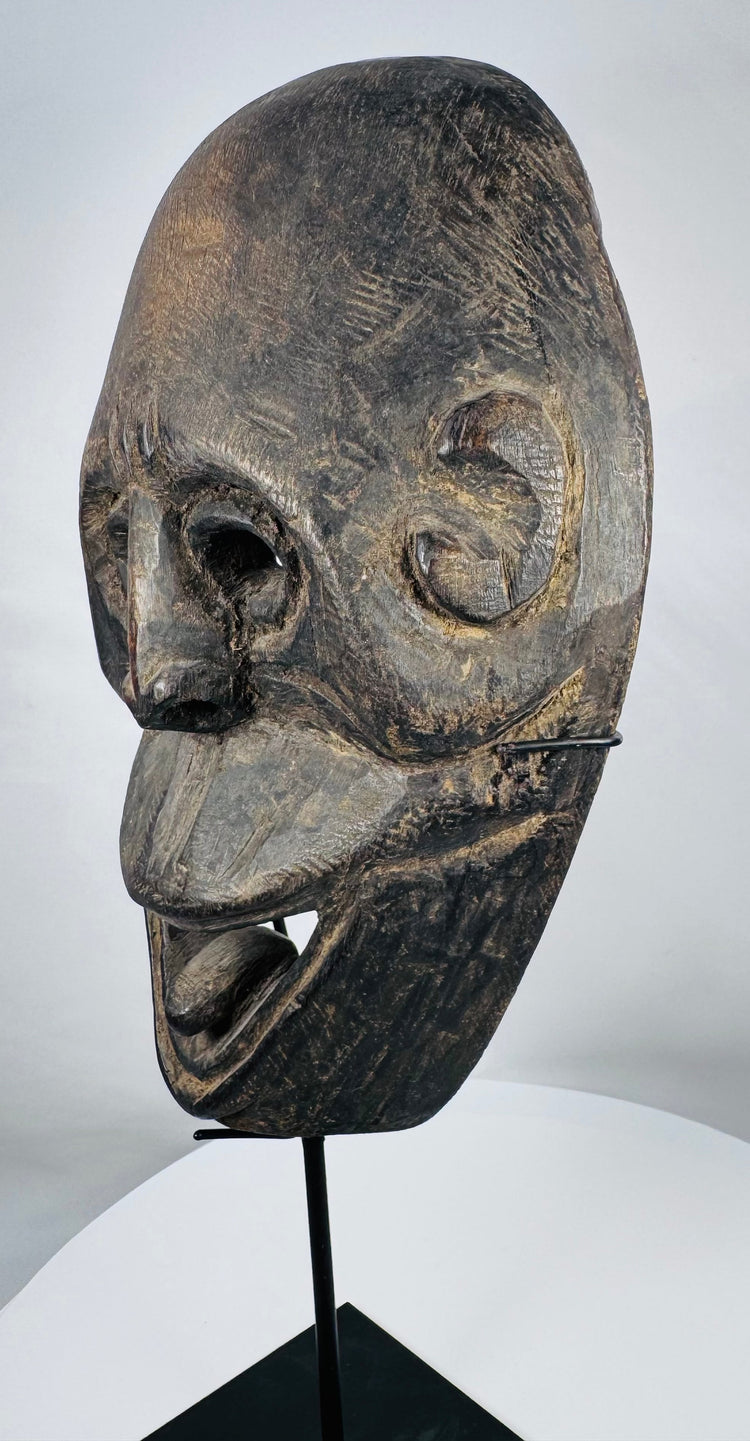 Atoni-associated ceremonial mask from West Timor featuring stylized facial features and rich age-related patina.