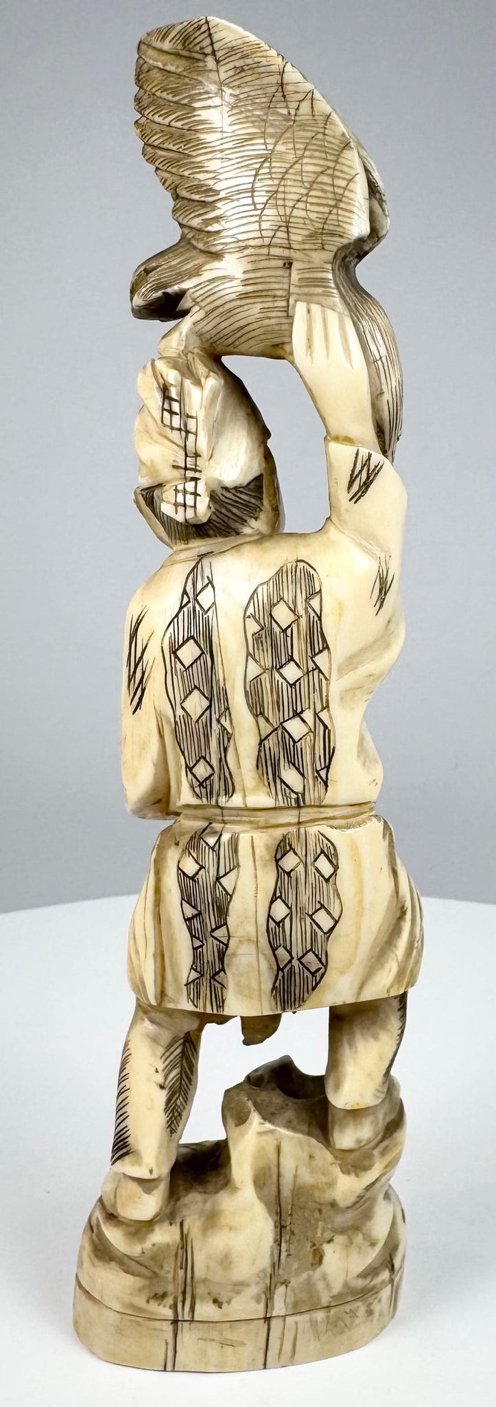 Japanese falconer carving with geometric clothing patterns and seigaiha head covering