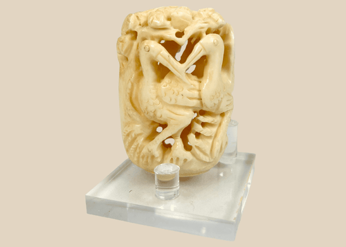 Japanese finely carved bone ornament featuring intertwined birds and foliage, Meiji to early 20th century