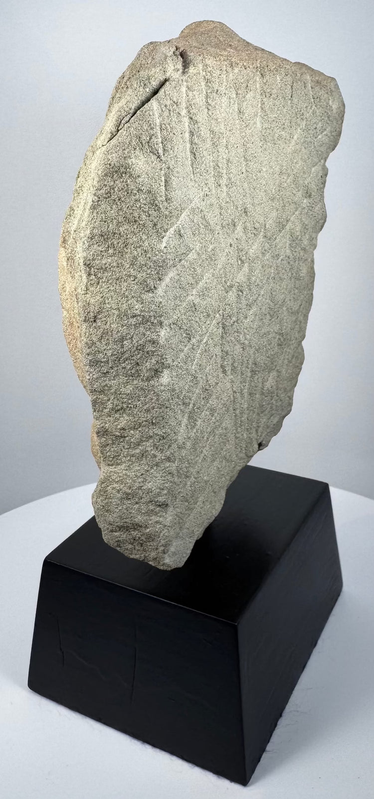 Rear view of Khmer Empire carved stone fragment showing diagonal chisel marks and irregular broken edge
