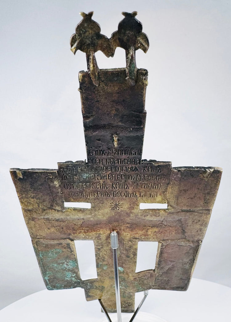 Russian bronze devotional cross depicting Christ on the cross surrounded by saints and sacred inscriptions.