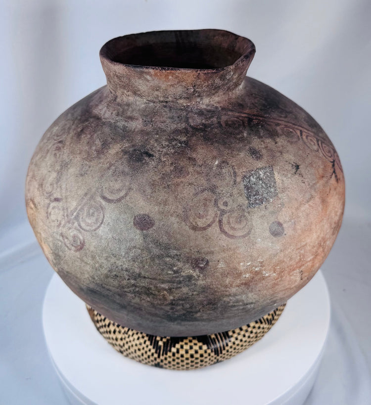 Antique Timor storage vessel featuring hand-painted scroll motifs and warm earthen patina