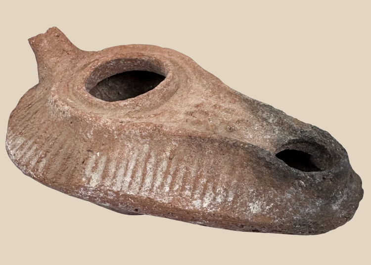 Late Antique terracotta oil lamp with elongated slipper-shaped body and soot-stained nozzle