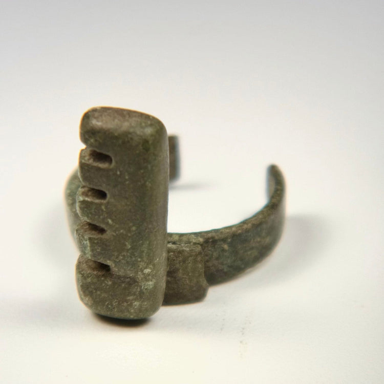 Late Imperial Roman bronze ring key with projecting rectangular bit, historic repair, surface pitting, and mineral encrustation