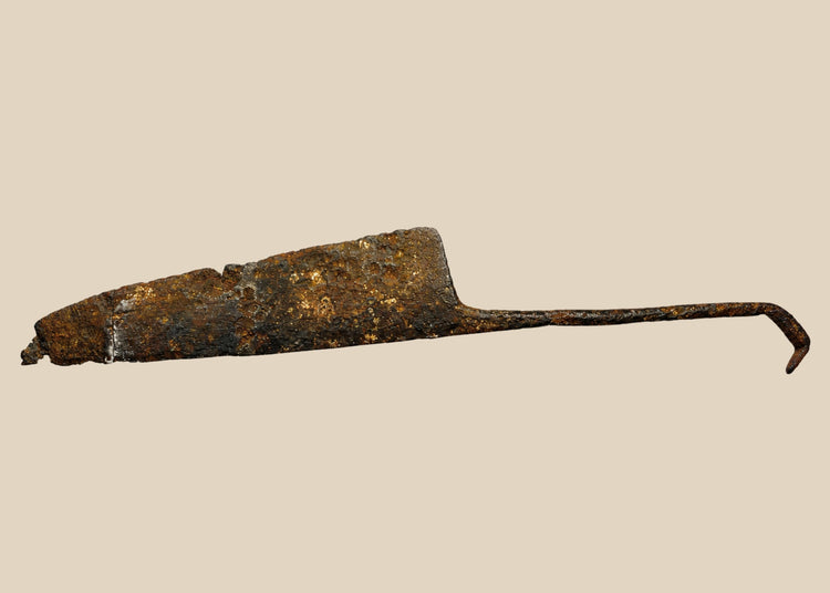 Excavated medieval European long knife, circa 12th–15th century CE, forged from iron/steel. Wide single-edged blade with tapered point, full-length tang with curved end, showing patina and surface aging. Functional weapon and utility tool reflecting High to Late Middle Ages craftsmanship and daily life.