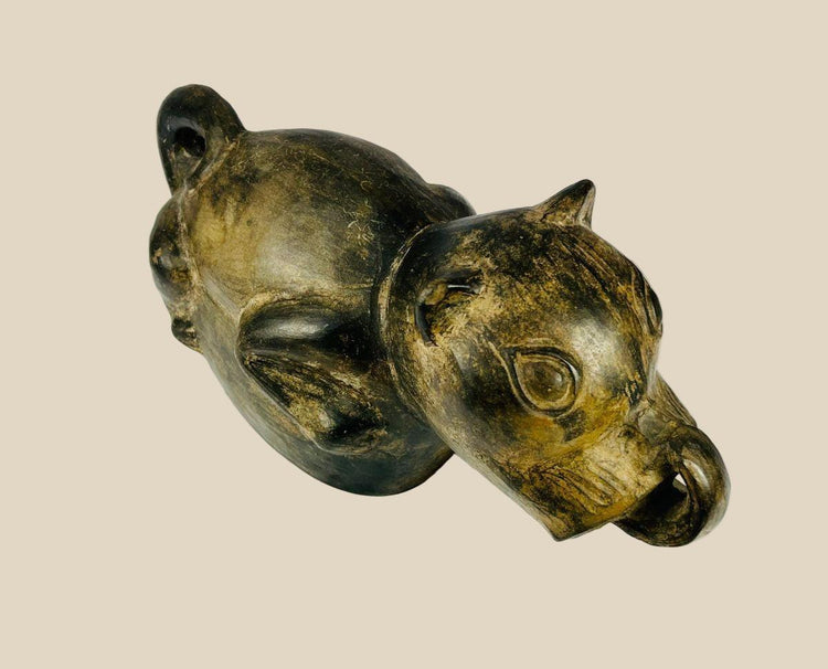 Pre-Columbian Moche stirrup-spouted terracotta vessel from Northern Peru, circa 200–700 AD, shaped as a stylized dog with finely sculpted facial features and dark slip coating. Functional and ritual object symbolizing loyalty and spiritual guidance, reflecting Moche ceramic artistry and cultural traditions.