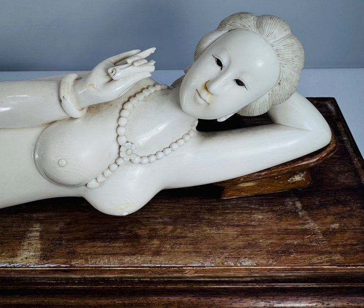 Close-up of the carved beaded necklace, bracelets and decorative details on the reclining figure