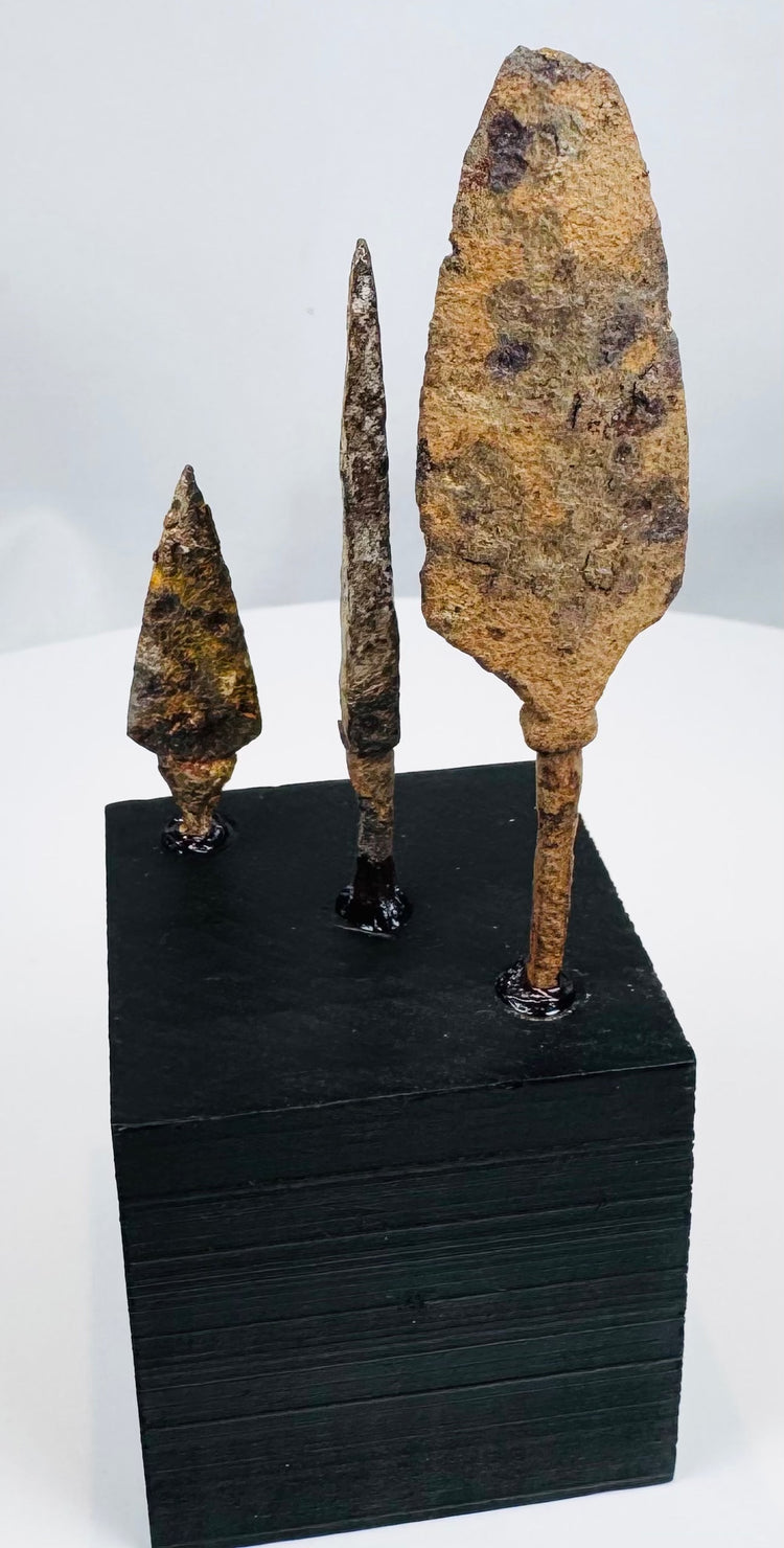 Three hand-forged European iron arrowheads in broad, bodkin, and triangular forms