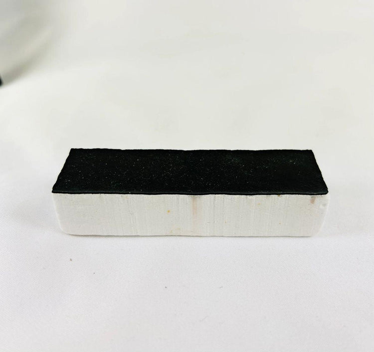 Authentic NASA Space Shuttle Thermal Protection System (TPS) tile from the 1980s, made of silica-based ceramic with black Reaction Cured Glass coating, used for reentry heat resistance, preserved in NASA-issued display case.