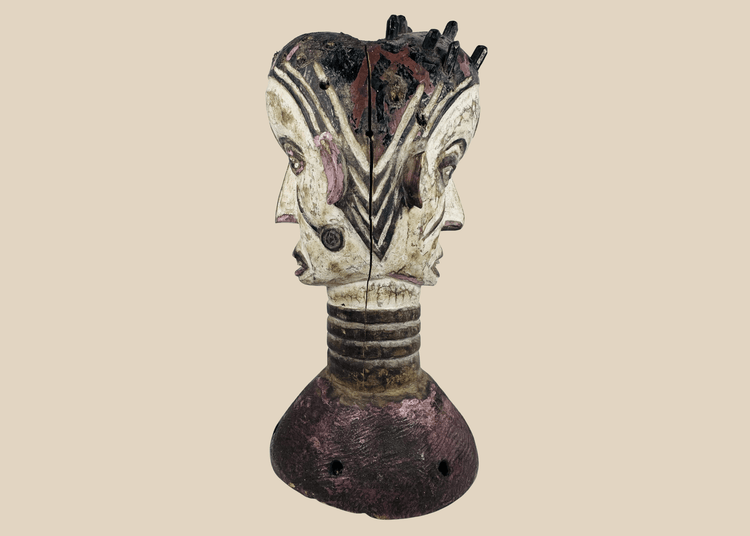 Nigerian Igbo Janus dance crest featuring opposing carved faces, painted decoration, and ceremonial masquerade symbolism.