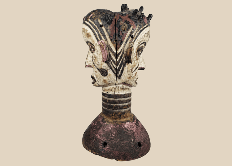Nigerian Igbo Janus dance crest featuring opposing carved faces, painted decoration, and ceremonial masquerade symbolism.