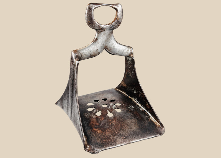 Authentic 17th-century Ottoman forged steel stirrup with triangular form, openwork floral cut-out footplate, and traces of silver damascening; historically used by elite cavalry for mounted combat and control.