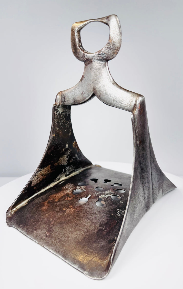 Ottoman Empire stirrup circa 17th century with pierced steel tread, broad arch, and preserved historic surface wear.