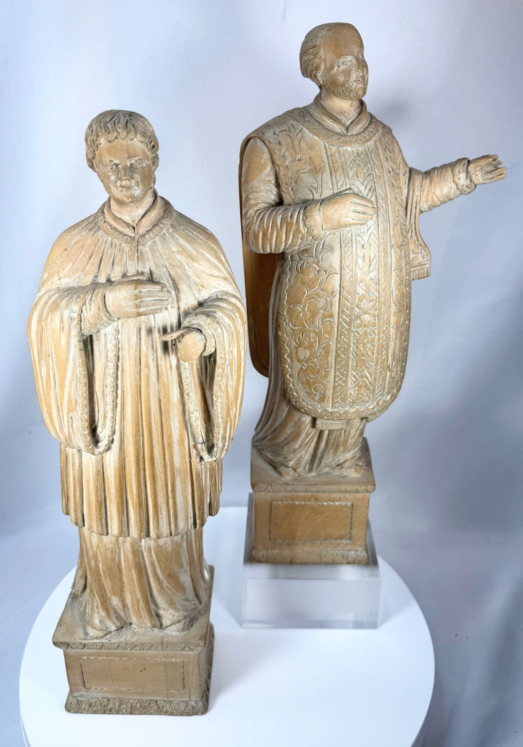 Antique Continental European wooden devotional sculptures with carved robes and aged natural patina.
