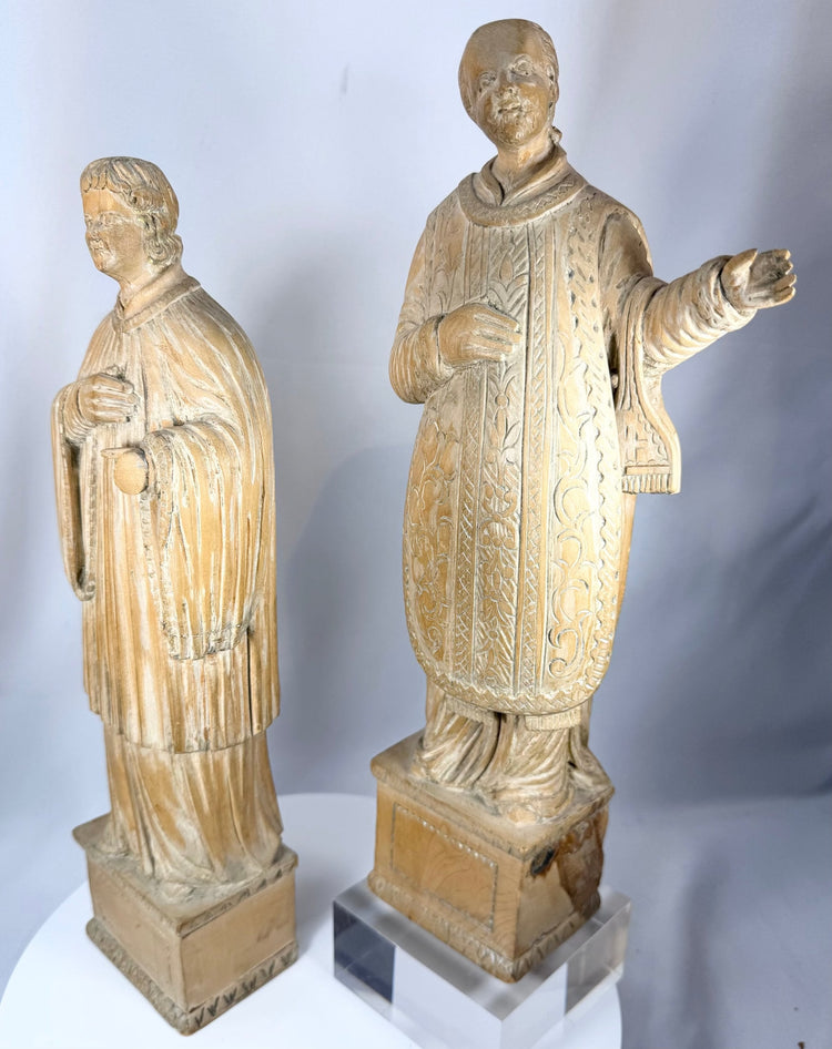 European devotional wooden figures displaying hand-carved drapery folds and ecclesiastical attire.
