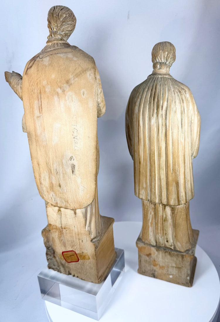 Hand-carved Christian figures with intricate robe decoration and centuries of aged character.