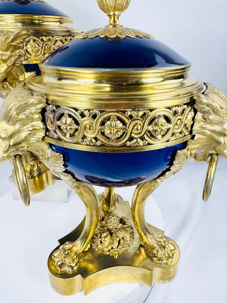 Close-up of a Louis XVI Revival vase displaying cobalt-blue porcelain, lion mask mounts, and ring handles.