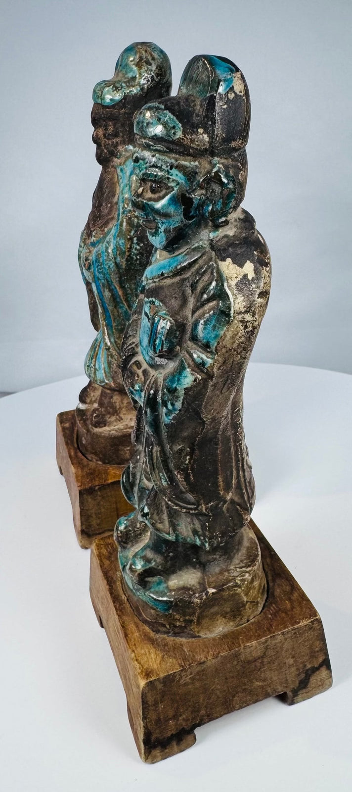 Antique Asian pottery figure pair displaying turquoise glaze loss and surface craquelure