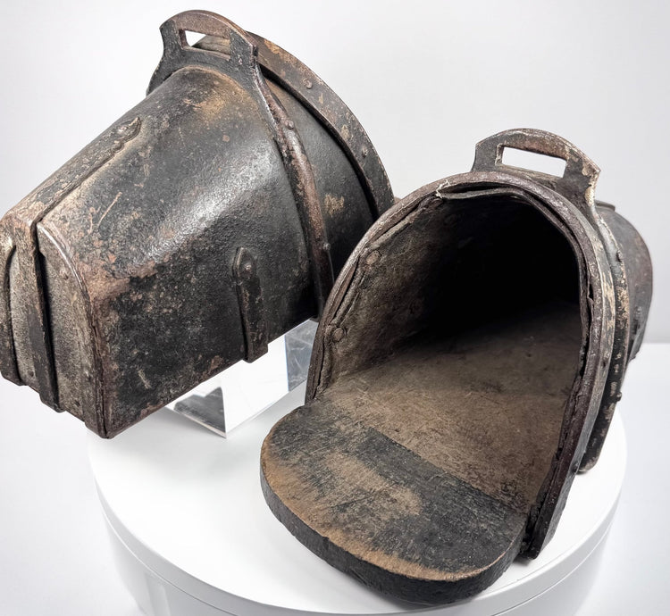 Historic European cavalry stirrups with arched iron hoods and reinforced wooden treads