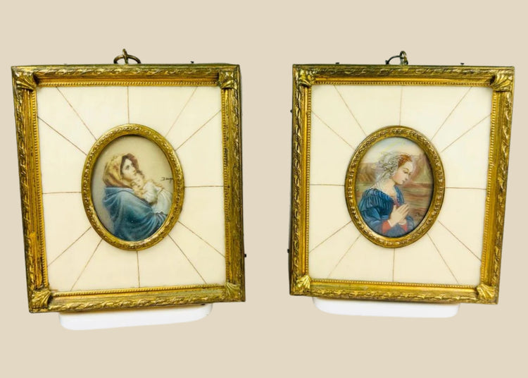 Pair of 19th century hand-painted miniature portraits in gilt frames with ivory-style panel insets. Depicting devotional female figures, one in prayer and one cradling a child. Original rectangular frames with oval portrait centers, fine detail and patina.