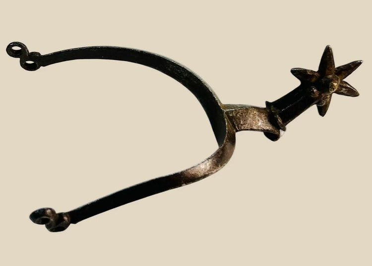 Late 16th–early 17th-century German Saxon spurs forged in iron/steel with large six-pointed rowels, curved frame with high rounded ridge, short hooked shanks with double eye terminals, patinated surfaces, reflecting Renaissance equestrian craftsmanship.
