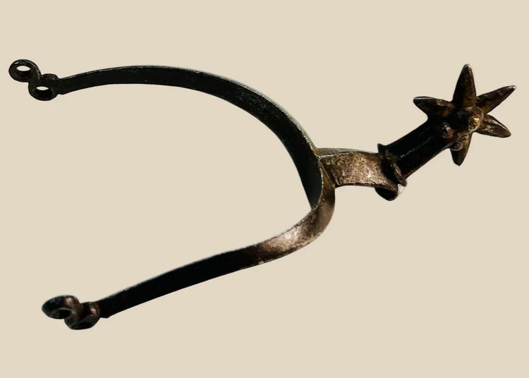 Late 16th–early 17th-century German Saxon spurs forged in iron/steel with large six-pointed rowels, curved frame with high rounded ridge, short hooked shanks with double eye terminals, patinated surfaces, reflecting Renaissance equestrian craftsmanship.