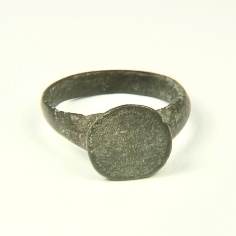Roman to Early Byzantine bronze ring, US size 8, with broad circular bezel and intact tapered hoop, circa 1st–8th century CE