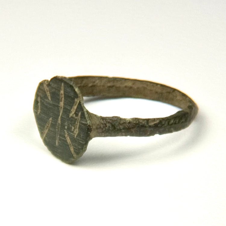 Profile view of Byzantine bronze ring showing integral bezel, slender band, and incised shoulder decoration