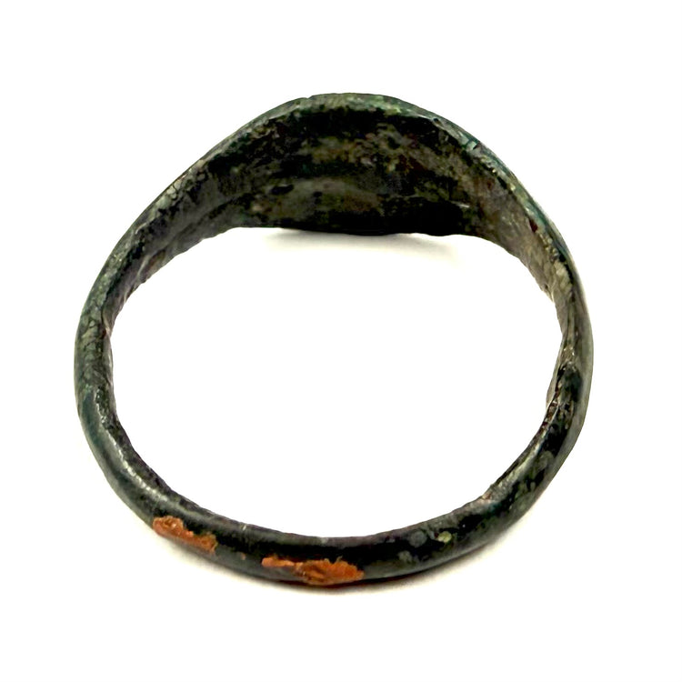 Close-up of Roman Imperial bronze finger ring showing smooth bezel surface and mineral deposits