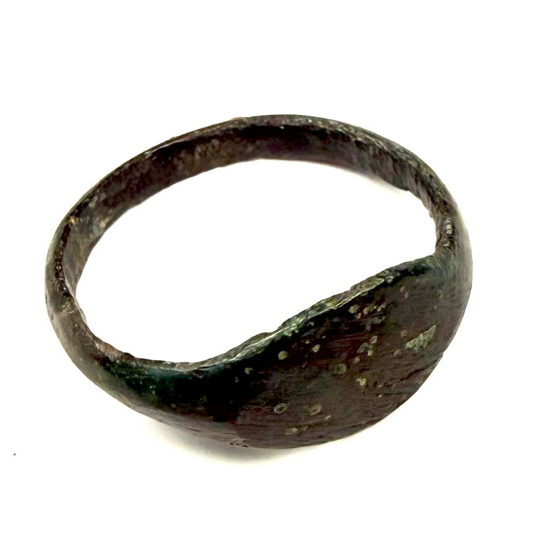 Side profile of ancient Roman bronze finger ring showing tapered shoulders and raised oval bezel