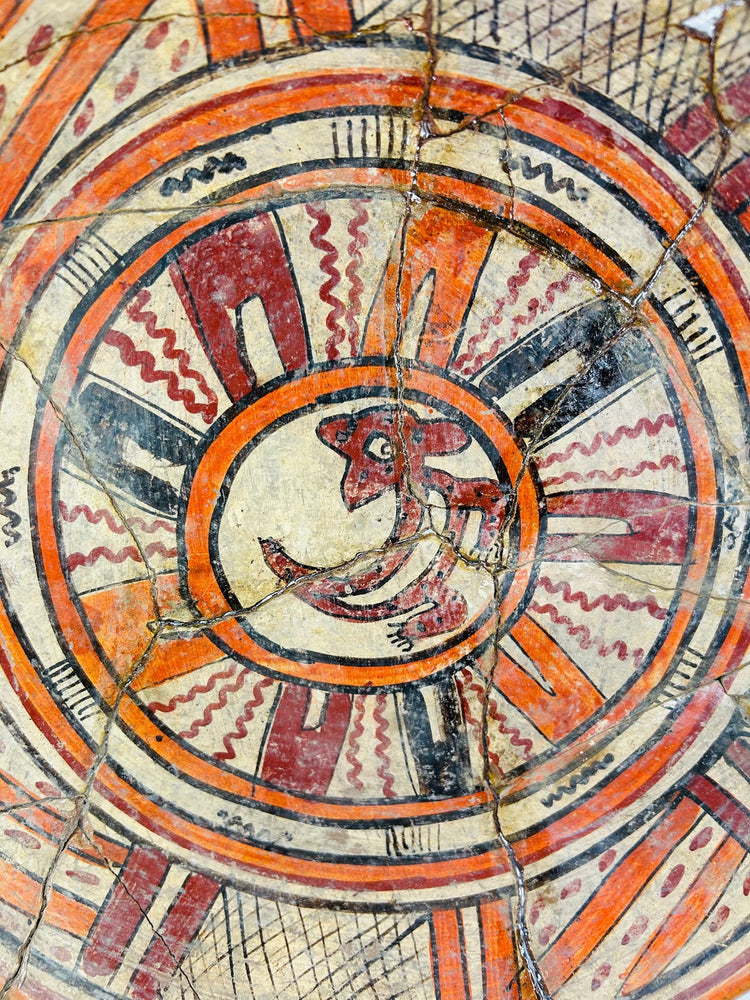 Close-up of zoomorphic center motif on ancient Mesoamerican plate, highlighting fine brushwork and mineral patina.