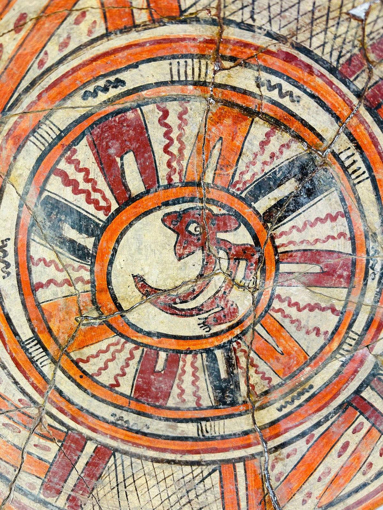 Close-up of zoomorphic center motif on ancient Mesoamerican plate, highlighting fine brushwork and mineral patina.