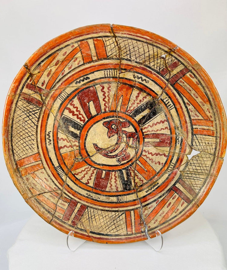 Ancient Mesoamerican polychrome ceramic plate with red zoomorphic motif and geometric bands