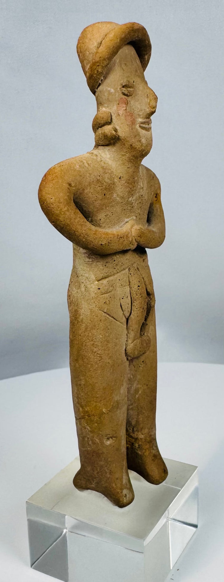 Ancient terracotta female effigy from Colima culture mounted for display on a custom lucite stand.