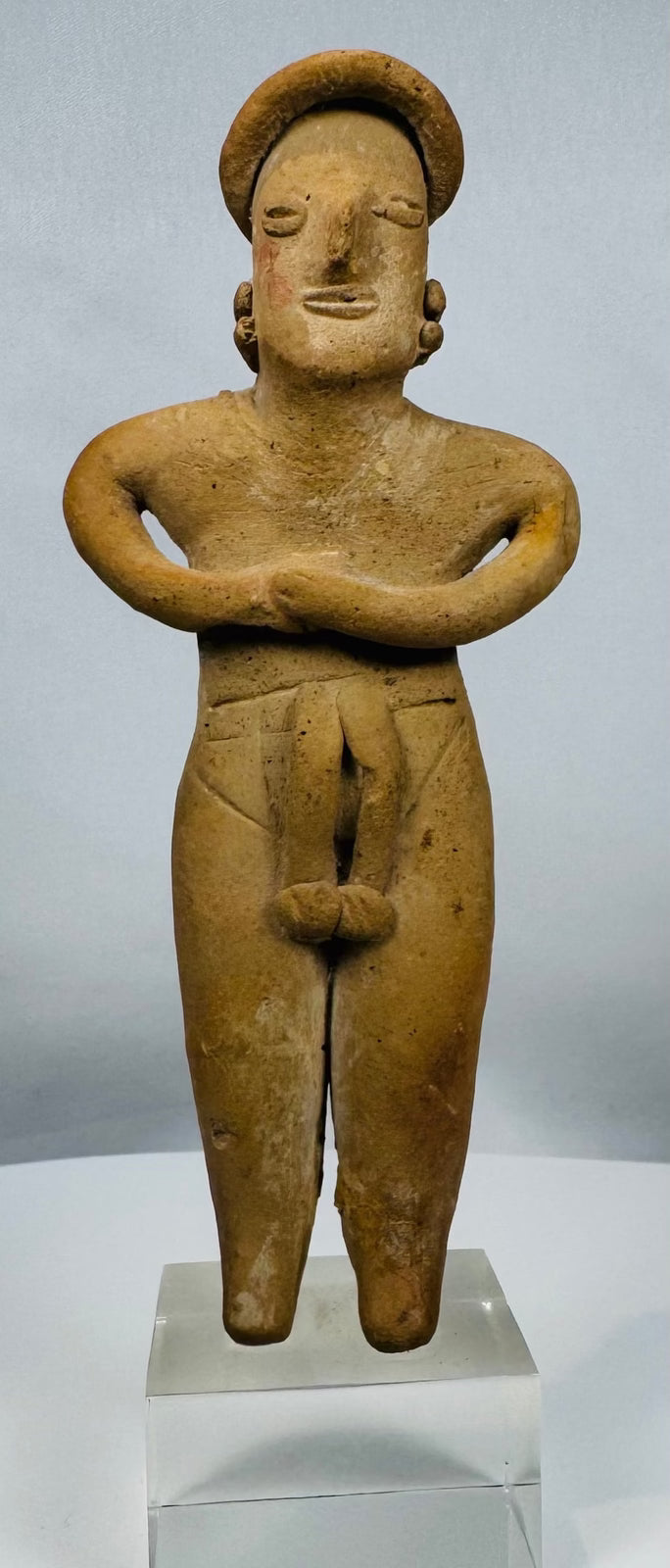 Ancient Colima female fertility figure in terracotta mounted on a lucite display stand.