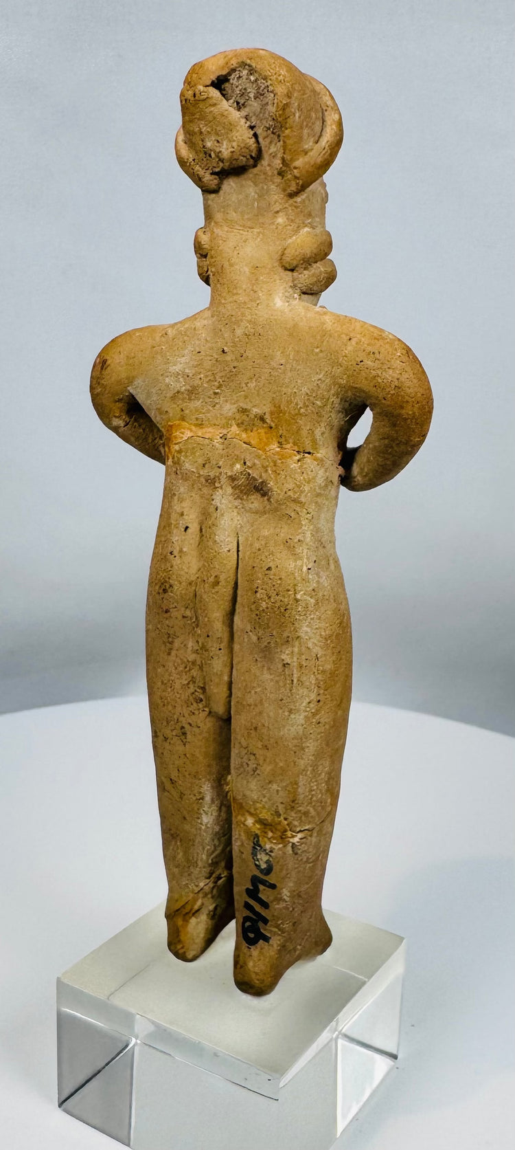 Colima gingerbread-style terracotta figure depicting a standing female with folded arms.