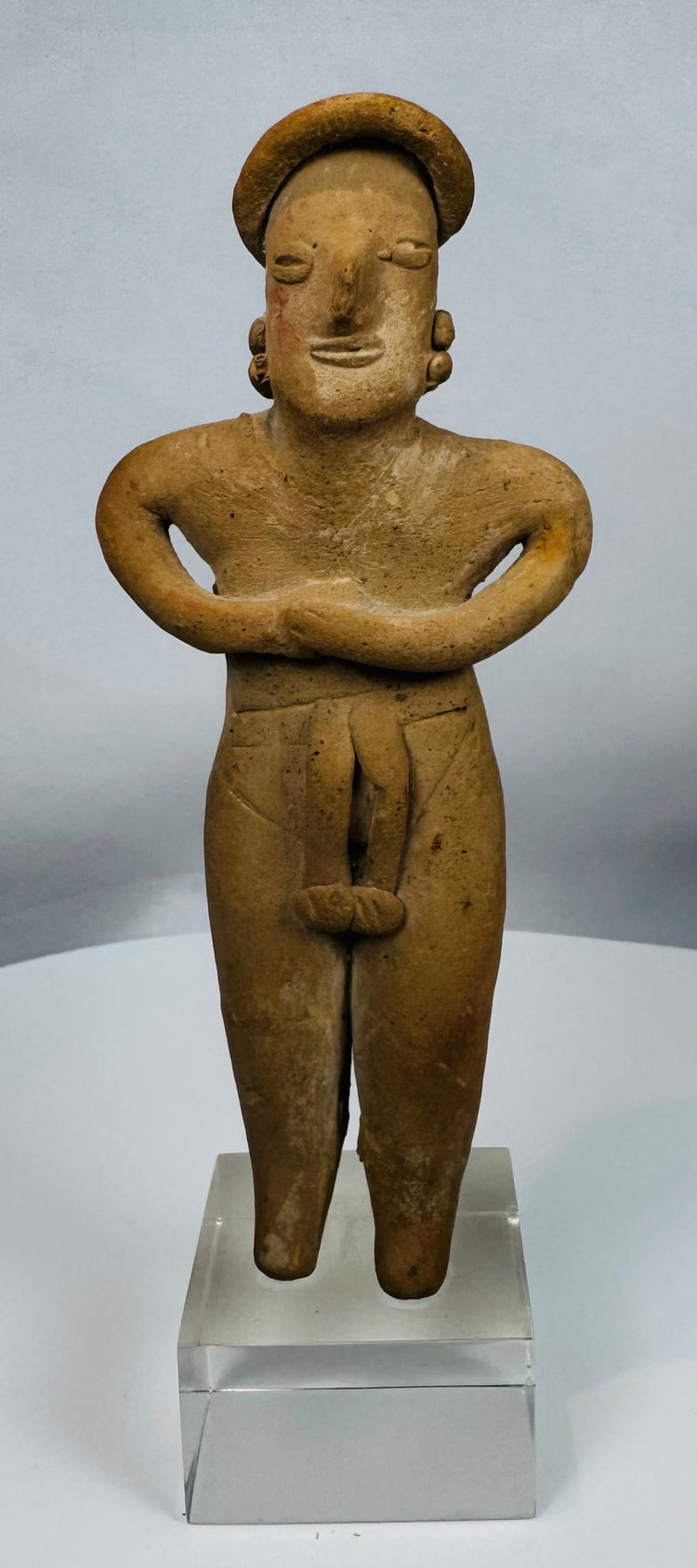 Hand-modeled Colima female figure showing folded-arm posture and traditional funerary symbolism.