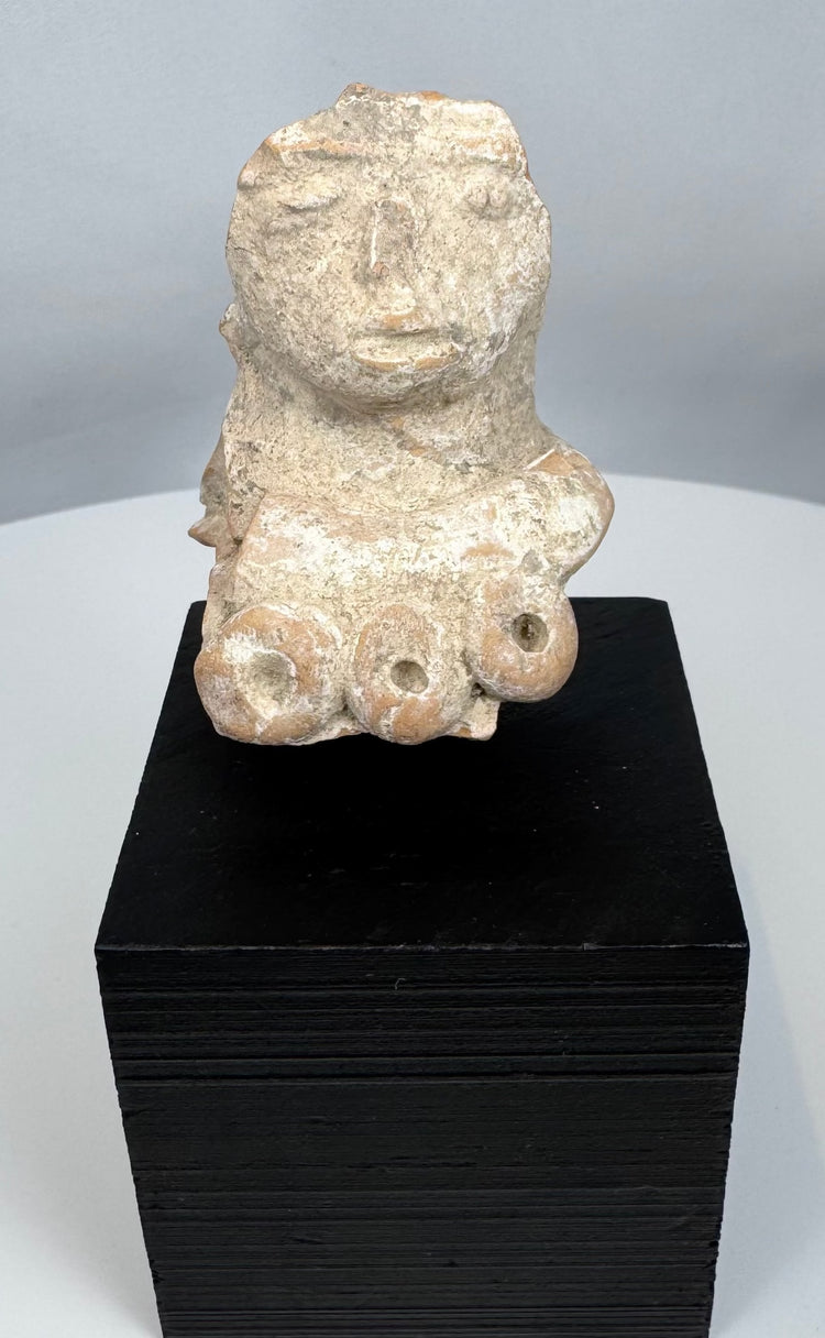 Pre-Columbian terracotta fertility figure fragment with expressive face and surviving upper torso.