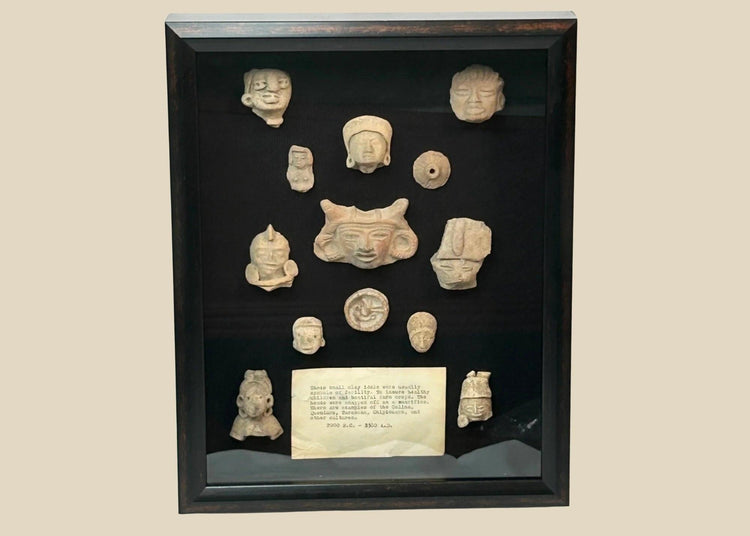 Shadowbox of 13 Pre-Columbian Mesoamerican terracotta fragments, including heads, maskettes, figurines, and spindle whorls from Teotihuacan and Veracruz traditions, 200 BCE–900 CE