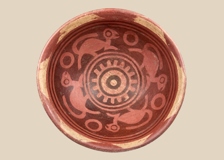 Terracotta Nariño culture bowl from Colombia and Ecuador, decorated with bichrome slip, negative resist geometric border, and four monkeys in the interior, dating from 800–1500 CE.