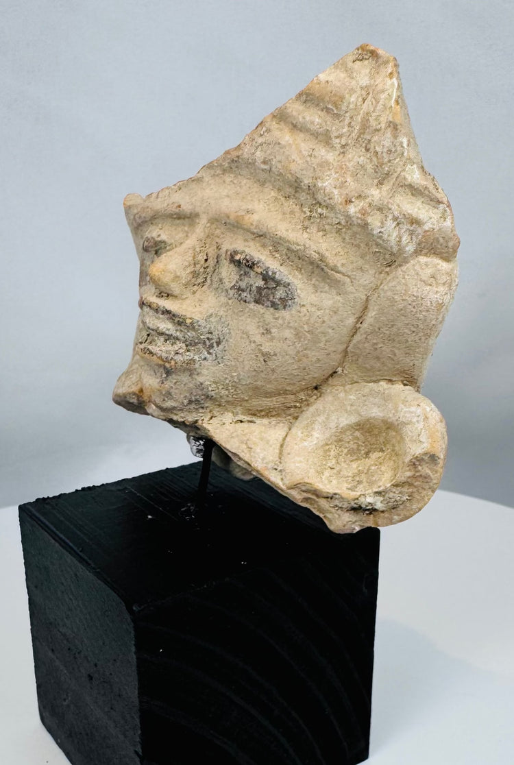 Mesoamerican terracotta sculpture fragment with high-relief facial features and weathered archaeological surface.