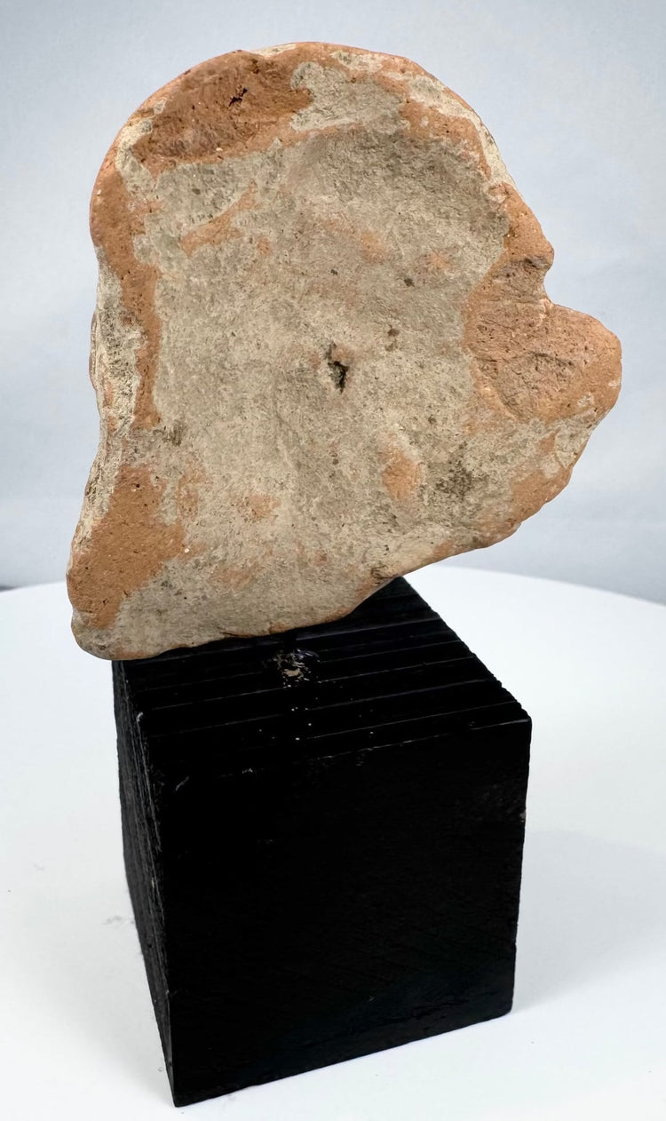Mesoamerican archaeological terracotta fragment depicting a stylized human face